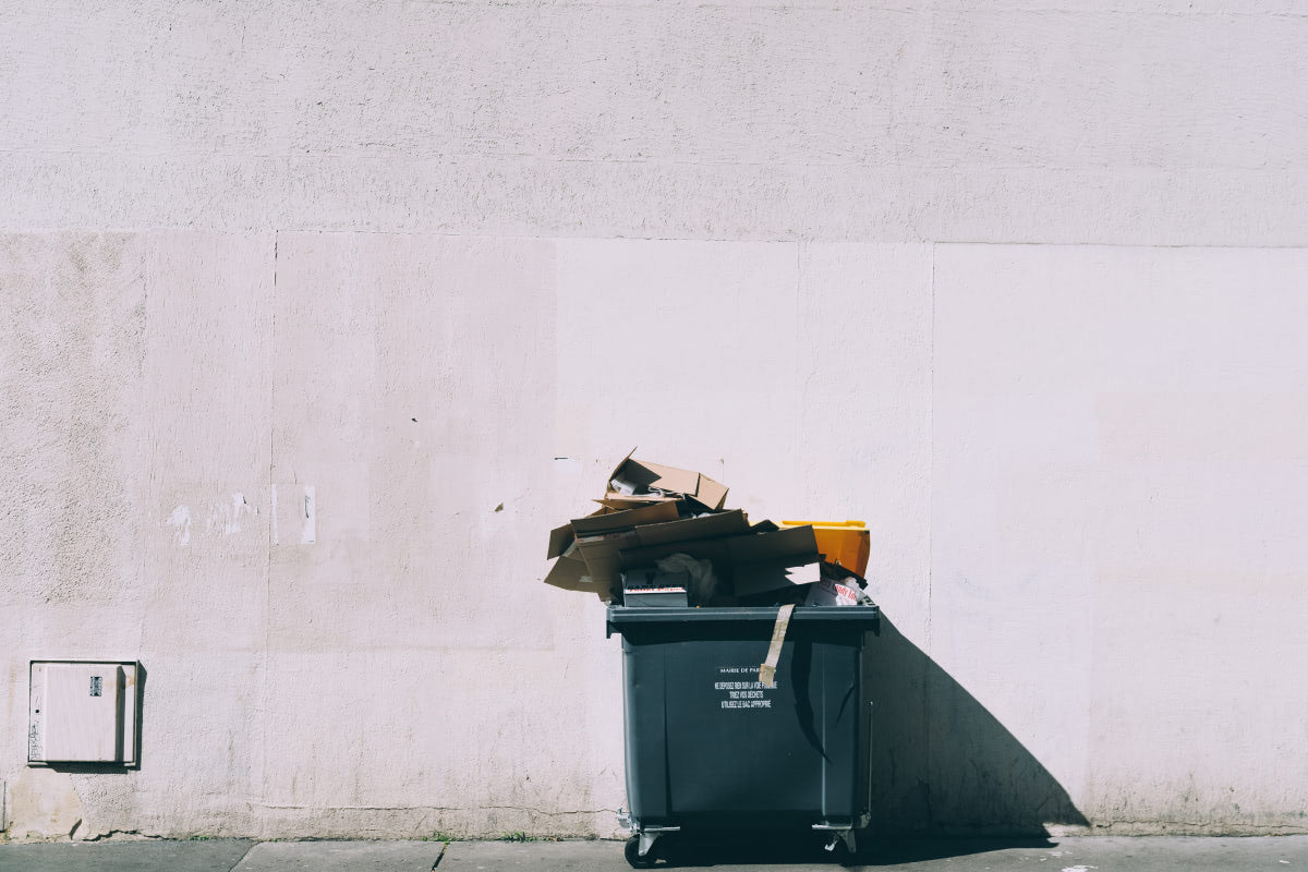 Overflowing bin on concrete backdrop
